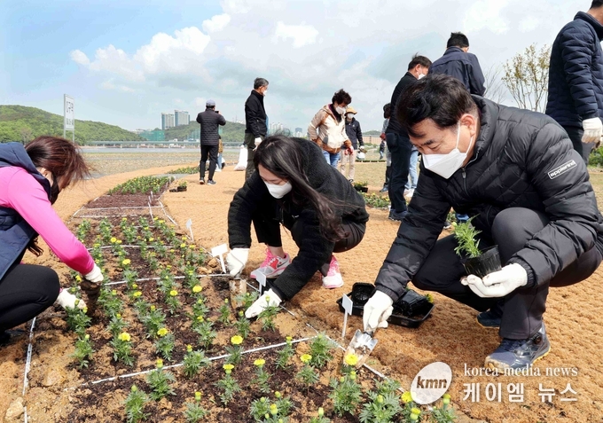 백군기 용인시장이 시민들과 함께 기흥호수공원 물빛정원에 메리골드를 심고 있다.
