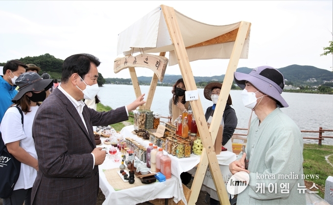 백군기 용인시장이 처인구 원삼면 용담호수에서 열린 '제2회 용담호수뚝마켓' 에서 관계자들과 이야기를 나누고 있다.