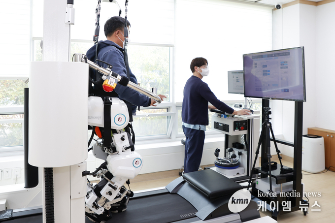 1-4. 안정경씨가 기흥장애인복지관에 설치된 워크봇G에 올라 재활치료를 받고 있다