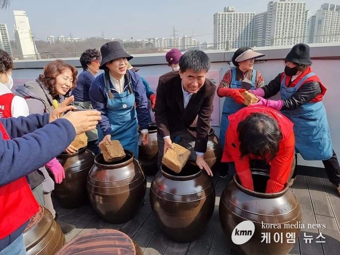 성길용 의장과 이정숙 지역사회 보장협의체 위원장이 장을 담그고 있다.<br>
사진/김영진기자