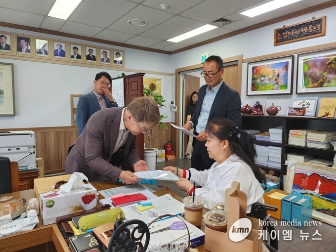 정효양 이 통장 협의회장이 정토근 안성시 부의장에게 성명서를 전달하고있다. 사진/김영진기자