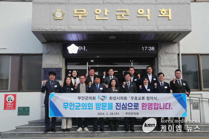 사진/무안군의회 배경으로 현수막을 든 화성시의회와 무안군의회 의원들 단체