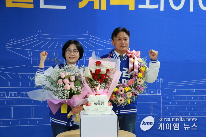 사진/더불어 민주당 김영진 당선자가 배우자와함게 축하의 꽃다발을 받고있다.