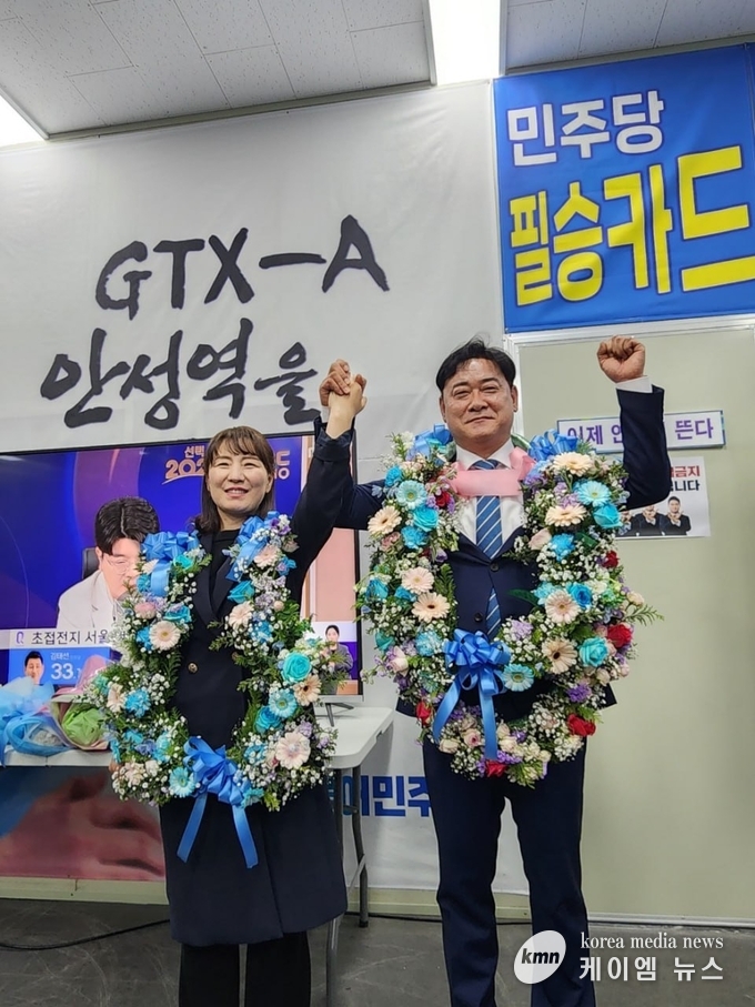 사진/윤종군 후보가 배우자와 함께 손을들어 기뻐하며 인사하고있다.