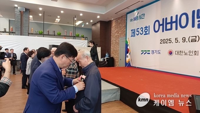 이선구 위원장이 어르신에게 카네이션을 달아 드리고 있다.