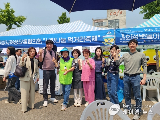 정명근 시장 배우자 이선희 여사(우측에서 다섯번째)는 사랑나눔 축제 행사장에서 관계자들과 화이팅 하고 있다. 사진/김영진 기자