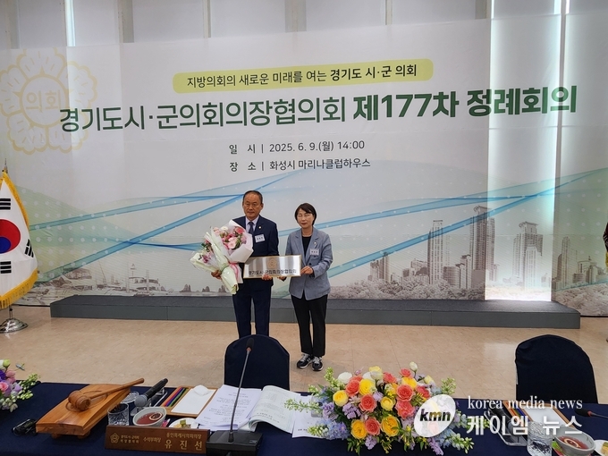 유진선 용인특례시의장이 제16기 경기도시,·군의회 의장협의회에 김승호 회장에게 꽃다발을 전달하고 기념촬영을하고있다.<사진/김영진기자>