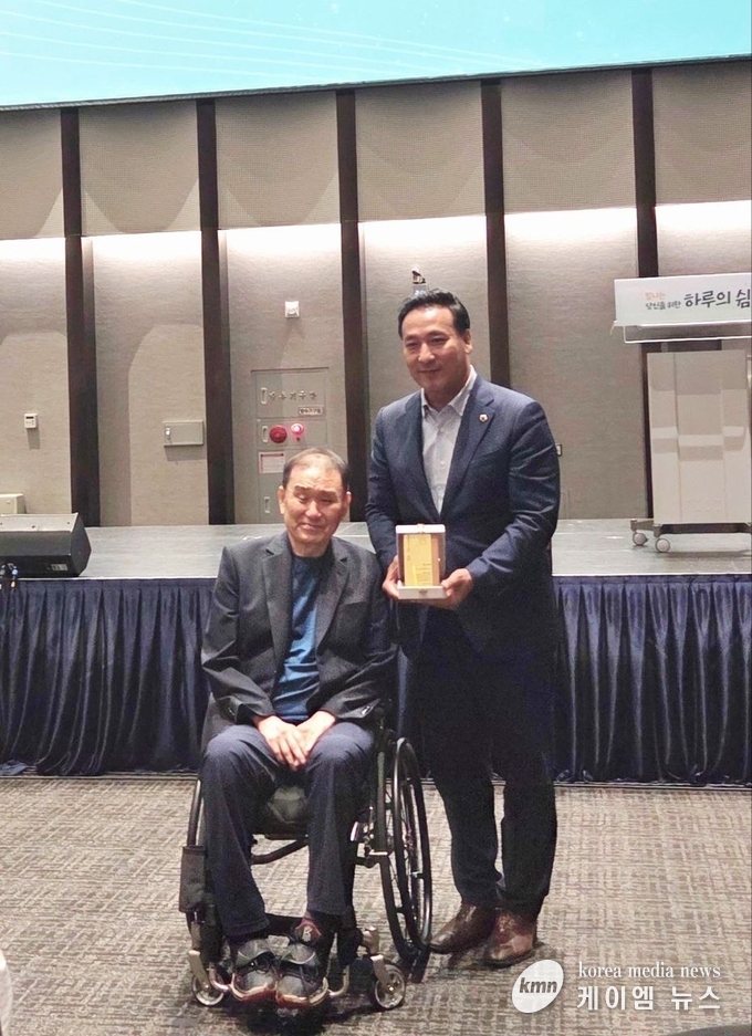 김 의원이 한국희귀난치성질환연합회 김재학 회장으로부터 감사패를 받고 희귀질환 가족과 함께하고 있다. 사진 경기도의회 제공