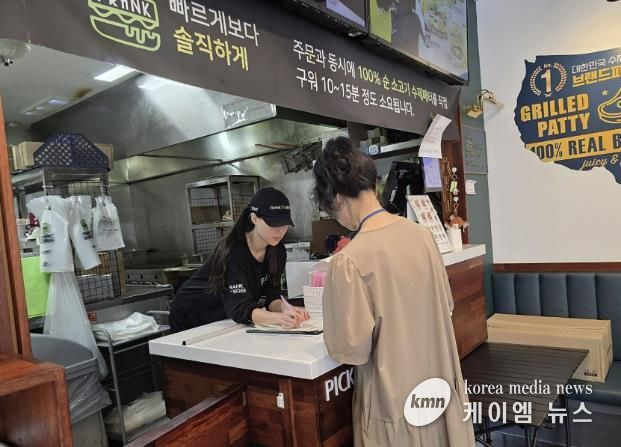 성남시 어린이 기호식품 전담관리원이 지난 9월 학교 주변 햄버거 판매점에서 영업자와 종업원의 건강진단 실시 여부를 점검하고 있다