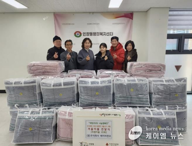 권소미 대표와 김경애 동장이 인창동 행정복지센터에서 이불 전달식을 진행하고 있다